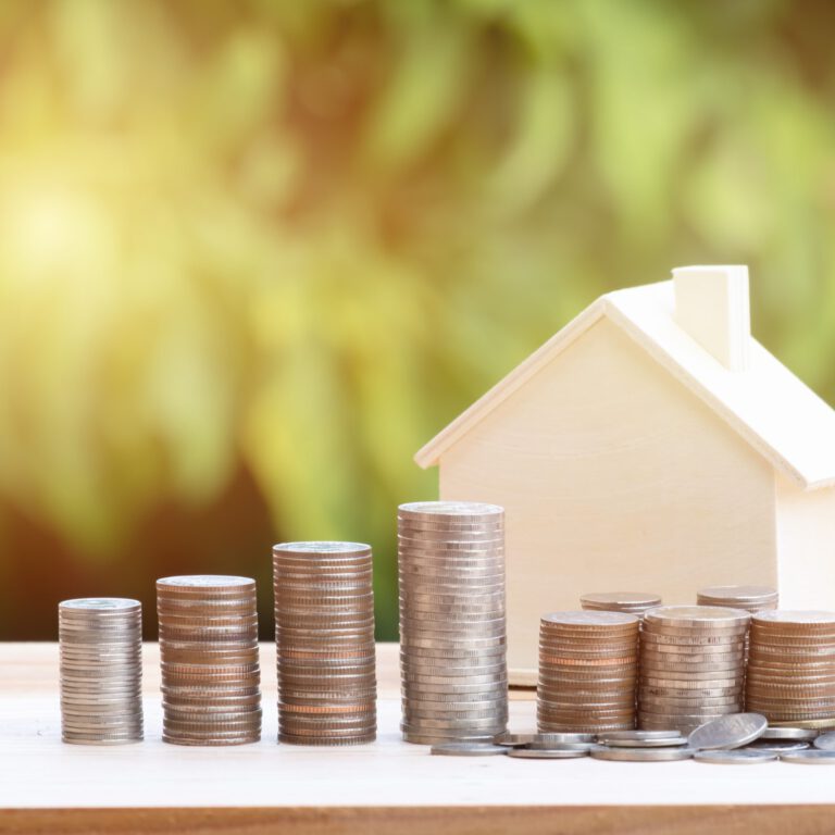 View Of coin stack with house model on green background, savings